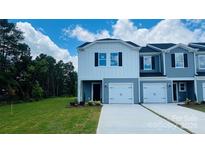Charming two-story townhome with white and blue siding, a one-car garage, and a well-maintained front lawn at 1403 Old Rivers Rd, Concord, NC 28027
