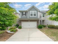 Charming two-story home with a two-car garage, beautiful landscaping, and a well-maintained lawn at 15524 Scholastic Dr, Charlotte, NC 28277