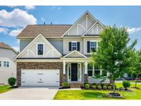 Charming two-story home features a manicured lawn, stone accents, and an attached two-car garage at 173 Morgans Branch Rd, Belmont, NC 28012