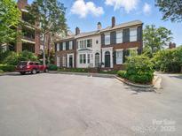Charming multi-unit brick home with a spacious parking lot, lush greenery, and classic architectural details at 2315 Selwyn Ave # F, Charlotte, NC 28207