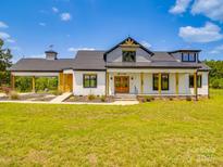 Stunning two-story modern farmhouse features a large front yard and a welcoming covered entry at 2410 Charlotte Hwy, York, SC 29745