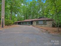 Charming single-story home with a stone facade, long driveway, and lush landscaping at 2730 Highway 557 Hwy, Clover, SC 29710