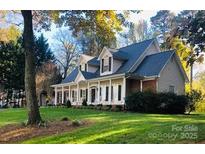 Charming two-story home with a welcoming front porch and beautifully landscaped yard at 390 Robinson Rd, Mooresville, NC 28117