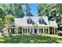 Charming one-story home featuring a manicured lawn, white trim, dormer windows, and welcoming front porch at 390 Robinson Rd, Mooresville, NC 28117