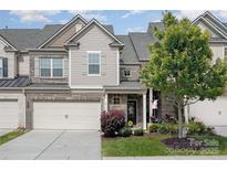 Charming townhome exterior featuring a well-manicured lawn and attached two-car garage at 4012 Woodsmill Rd, Fort Mill, SC 29707