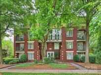 Beautiful brick condo building featuring mature trees, landscaping and private balconies at 416 Queens Rd # 10, Charlotte, NC 28207