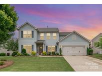 Charming two-story home featuring a manicured lawn, attached two-car garage, and beautiful landscaping at 5092 Nighthawk Dr, Indian Land, SC 29707