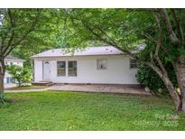 Charming single-story home with white siding, metal roof, and mature trees surrounding the property at 535 Norman Fair Ave, Lincolnton, NC 28092