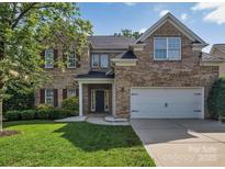 Charming brick two-story home featuring a two-car garage and well-manicured lawn in a lovely neighborhood at 6004 Trailwater Rd, Charlotte, NC 28278