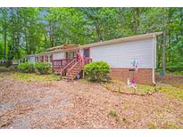 Charming single-story home with front porch and mature trees, nestled on a wooded lot at 6010 Old Pageland Marshville Rd, Marshville, NC 28103
