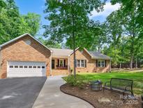 Charming brick home with an attached garage, a bench and beautiful landscaping at 7300 Bailywick Dr, Waxhaw, NC 28173