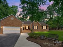 Charming brick home with a well-manicured lawn, inviting front porch, and an attached two-car garage, perfect for suburban living at 7300 Bailywick Dr, Waxhaw, NC 28173