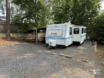 Prowler camper parked on a gravel lot, surrounded by trees at 103 Powder Horn Trl, Mount Gilead, NC 27306