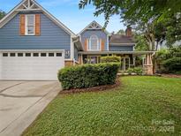 Charming blue two-story home with a white garage door and well-manicured lawn at 12092 Spinnaker Dr, Fort Mill, SC 29708