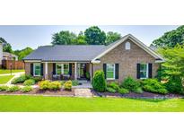 Charming one-story brick home with well-manicured lawn and inviting front porch at 12311 Bentcreek Ln, Matthews, NC 28105