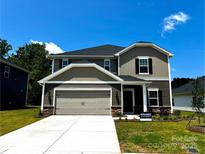 Two-story home featuring a gray-beige exterior, two-car garage, and manicured front yard at 1423 Windy Park Dr, Stanley, NC 28164