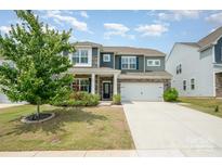 Charming two-story home with a well-manicured lawn and two-car garage at 150 Haddonsfield Dr, Mooresville, NC 28115
