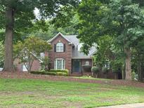 Beautiful brick home featuring manicured front yard and mature trees providing shade and curb appeal at 150 Pinnacle Shores Dr, Mooresville, NC 28117