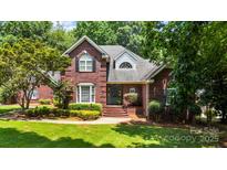 Beautiful brick two-story home with landscaped lawn and manicured shrubs on a sunny day at 150 Pinnacle Shores Dr, Mooresville, NC 28117