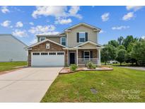 Inviting two-story home featuring stone accents, a well-manicured lawn, and an attached two-car garage at 1709 White Willow Ave, Gastonia, NC 28054