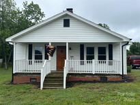 Charming home with a covered front porch, white siding, and black shutters at 200 Prospect Church Rd, Albemarle, NC 28001