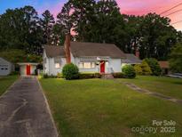Charming one-story home with a well-maintained lawn and a bright red front door at 216 Hillcrest Pl, Salisbury, NC 28144