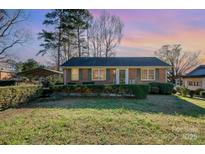 Charming brick home features a well-manicured front yard and lush green hedges, perfect for curb appeal at 2809 Markland Dr, Charlotte, NC 28208