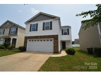 Charming two-story home featuring a stone facade, white siding, and a two-car garage at 3014 Green Apple Dr, Dallas, NC 28034