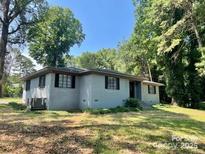 Charming single-story home featuring a classic facade, large windows, and mature trees in a serene, landscaped setting at 3217 Celanese Rd, Rock Hill, SC 29732