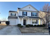 Two-story home features white siding, black shutters, a one-car garage, and a well-manicured front yard at 3244 Oulten Sw St, Concord, NC 28027