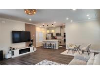 Open-concept living room and kitchen with modern decor, island seating, and stylish light fixtures at 332 Cranford Dr, Pineville, NC 28134