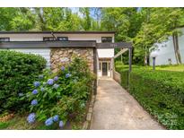 Inviting exterior featuring stone accents, lush landscaping, and a charming walkway leading to the front door at 3737 Winding Creek Ln, Charlotte, NC 28226