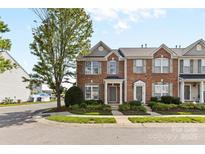 Charming brick townhome featuring a well-manicured lawn and tasteful landscaping, offering curb appeal at 4208 Coulter Xing, Charlotte, NC 28213