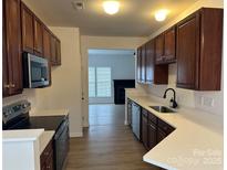Modern kitchen with stainless steel appliances, light countertops, and wood cabinets at 4208 Coulter Xing, Charlotte, NC 28213