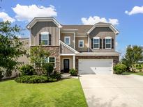 Charming two-story home with a stone and siding exterior, well-manicured lawn, and attached two-car garage at 4310 Coachwhip Ave, Lancaster, SC 29720