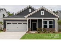 Charming home featuring a two-car garage, neat landscaping, and a welcoming covered front porch at 438 Bent Burr Crk, York, SC 29745