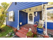 Charming blue home featuring a cozy front porch and decorative landscaping at 455 Wood Ave, Kannapolis, NC 28083