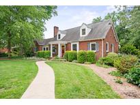 Charming brick home with lush landscaping, walkway, and inviting front porch with bright red door at 81 21St Nw Ave, Hickory, NC 28601