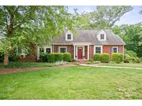 Charming brick home with a well-manicured lawn, complemented by a vibrant red door and inviting greenery at 81 21St Nw Ave, Hickory, NC 28601