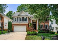 Stately two-story brick home with a landscaped front yard, driveway, and a two car garage at 8500 Headford Rd, Charlotte, NC 28277