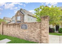 Charming townhome with a brick sign and landscaped front, nestled within the Ardrey Court community at 10105 Community House Rd, Charlotte, NC 28277