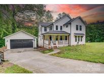 Charming two-story farmhouse with inviting front porch, detached garage and basketball hoop at 1062 Willow Ridge Ln, Fort Mill, SC 29707
