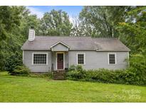 Charming one-story home with gray siding, mature trees, and a well-maintained front lawn at 147 Hansard Dr, Charlotte, NC 28214