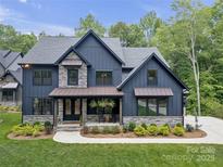 Beautiful two-story home featuring a stylish blue exterior with stone accents and a welcoming front porch at 18238 Youngblood N Rd, Charlotte, NC 28278