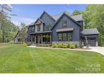 Beautiful two-story home with stone accents, a well-manicured lawn, and stylish architecture at 18238 Youngblood N Rd, Charlotte, NC 28278