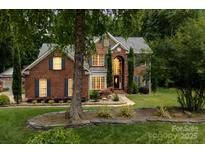 Beautiful two-story brick home with manicured lawn and large windows providing abundant natural light at 2031 Brook View Ct, Matthews, NC 28104