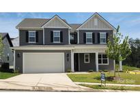 New two-story home featuring a two-car garage, neutral siding, black shutters, and manicured front lawn at 220 Windy Dell Dr, Tega Cay, SC 29708