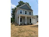 Charming two-story home featuring a welcoming front porch with white columns and an attached one-car garage at 242 North Ave, Troutman, NC 28166