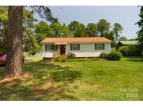 Charming single-story home featuring a well-maintained lawn and mature trees at 252 Chuckwood Rd, Mooresville, NC 28117