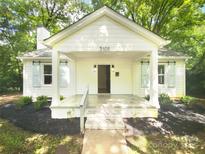 Charming single-Gathering home featuring a welcoming front porch and black mulch landscaping at 3109 Morson St, Charlotte, NC 28208